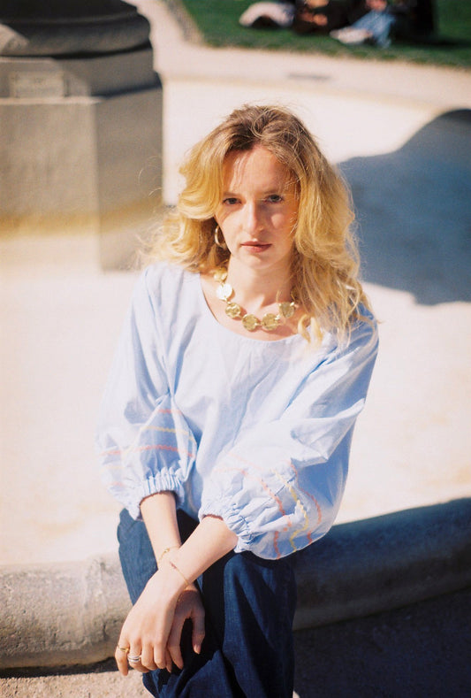 notre modèle portant la blouse Giulia en popeline de coton bleu ciel, made in France