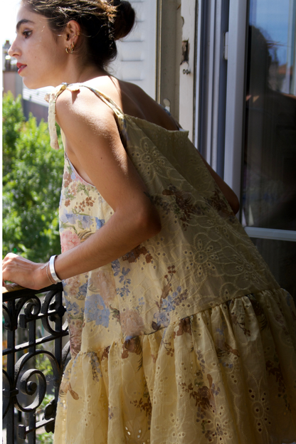 Focus sur le bas évasé en broderie anglaise jaune et coton d'une robe d'été fluide et romantique.