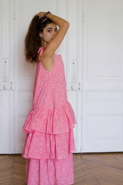 Plan de profil : Le mouvement de la robe maxi à volants rose La Sévillane, mettant en valeur la fluidité du tissu et la personnalisation sur-mesure de l'atelier.