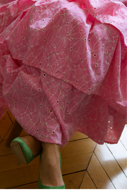 Gros plan texture et volume : Les détails tactiles de la broderie anglaise artisanale italienne de couleur rose tendre et l'empilement généreux des volants couture.