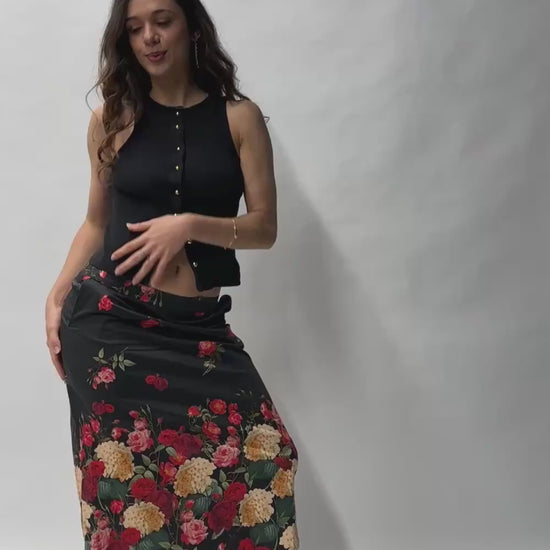 Jupe en coton à imprimé floral coloré, portée avec un débardeur noir dans une mise en scène urbaine.