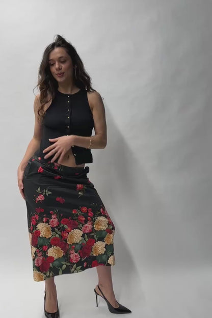Jupe en coton à imprimé floral coloré, portée avec un débardeur noir dans une mise en scène urbaine.