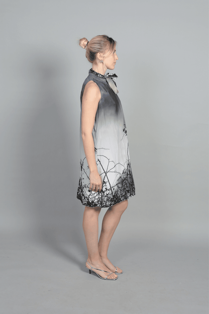 "Vue de profil de la robe Bella montrant le tombé impeccable de la soie. Silhouette élancée sans manches, idéale à porter avec des bottes en cuir vernis pour un contraste de matières audacieux. Robe de créateur fabriquée à Bourges."