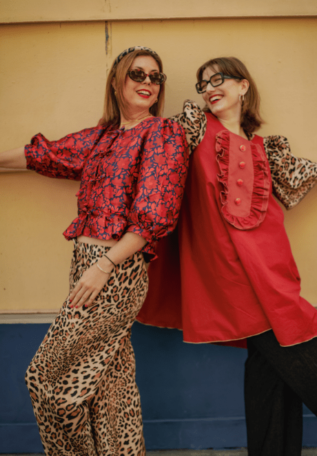 Femme portant la Robe Jacinthe rouge sur top léopard dans une rue parisienne, style mode française, look tendance automne hiver

