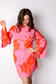 Robe mini coupe droite rétro en popeline de coton légère rose vif, grand imprimé floral orange façon tournesol oversized, manches longues extra-évasées style kimono, encolure bateau arrondie. Robe femme été colorée et élégante, made in France par Carlis.