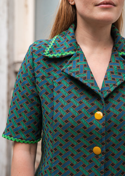 Détail du col chemisier oversize en jacquard de coton italien — revers larges style années 70, imprimé géométrique vert forêt et bleu canard, finition passepoil vert vif sur l'encolure. Robe élégante femme, coupe rétro chic, made in France par Carlis.
